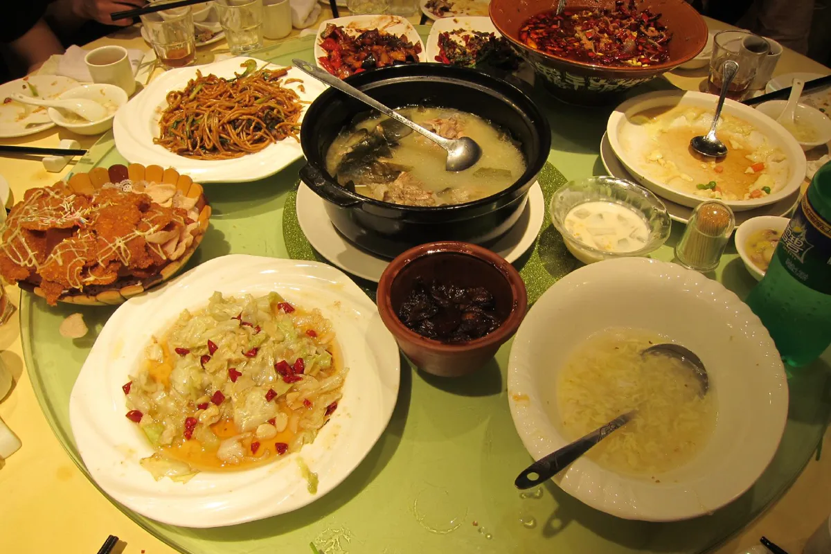 Shared meal with several dishes on a round table in China