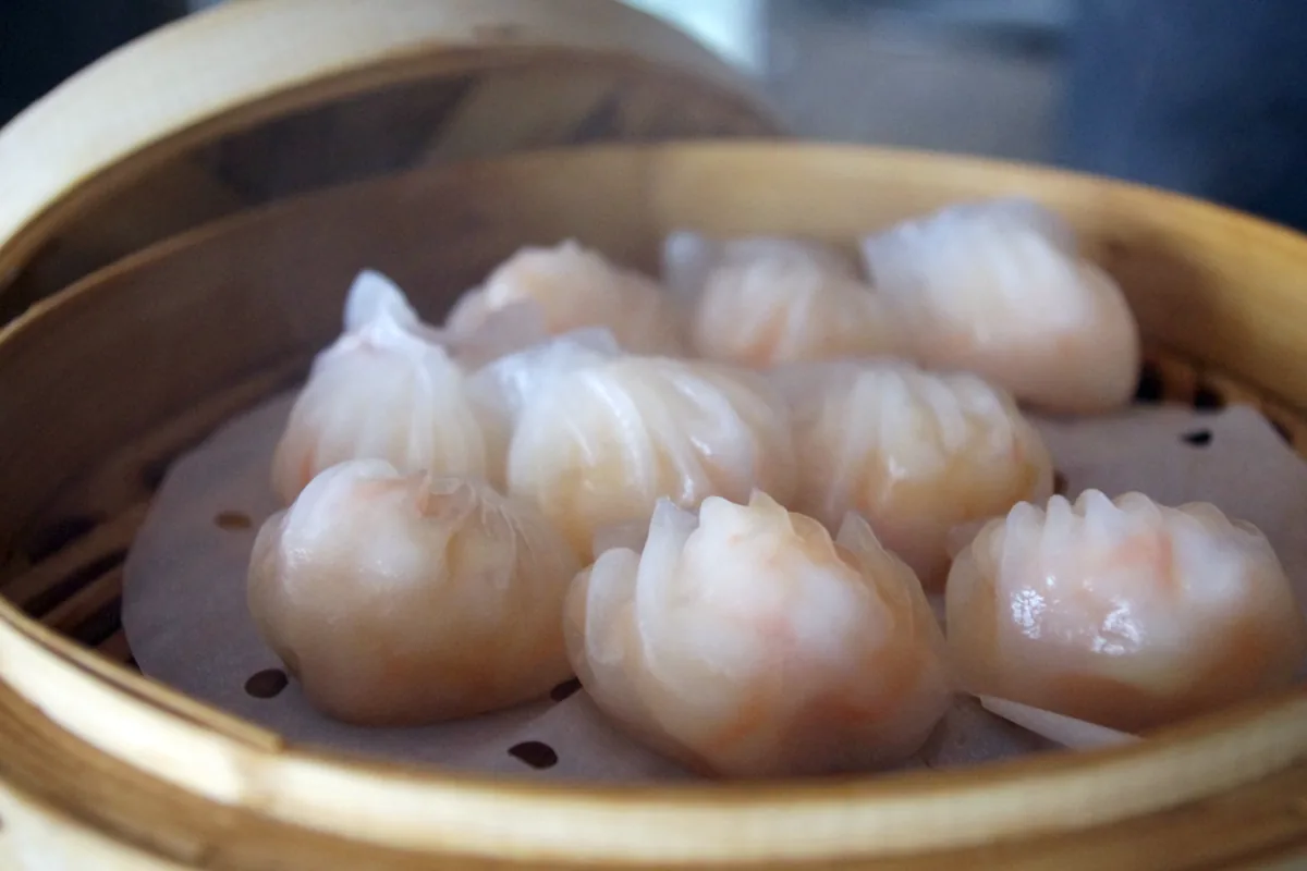 Translucent har gow shrimp dumplings in a bamboo steamer
