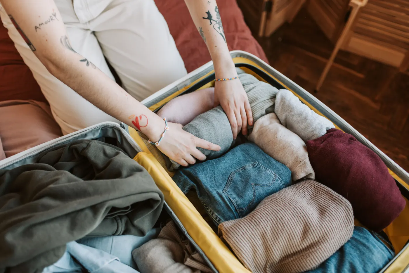 Warm clothes being packed into an open suitcase