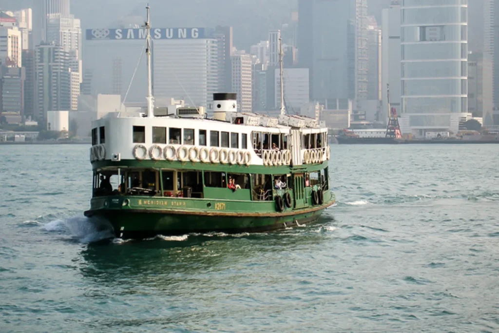 Green-and-white Star Ferry crossing Victoria Harbour in Hong Kong