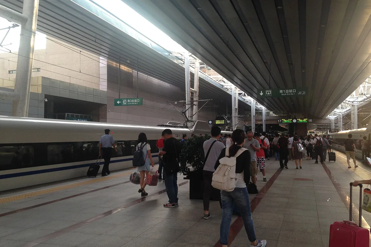 Passengers and train on a platform at Beijing West Railway Station