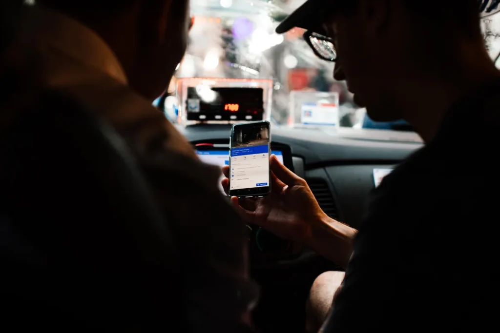 Passenger checking a route on a smartphone inside a car at night