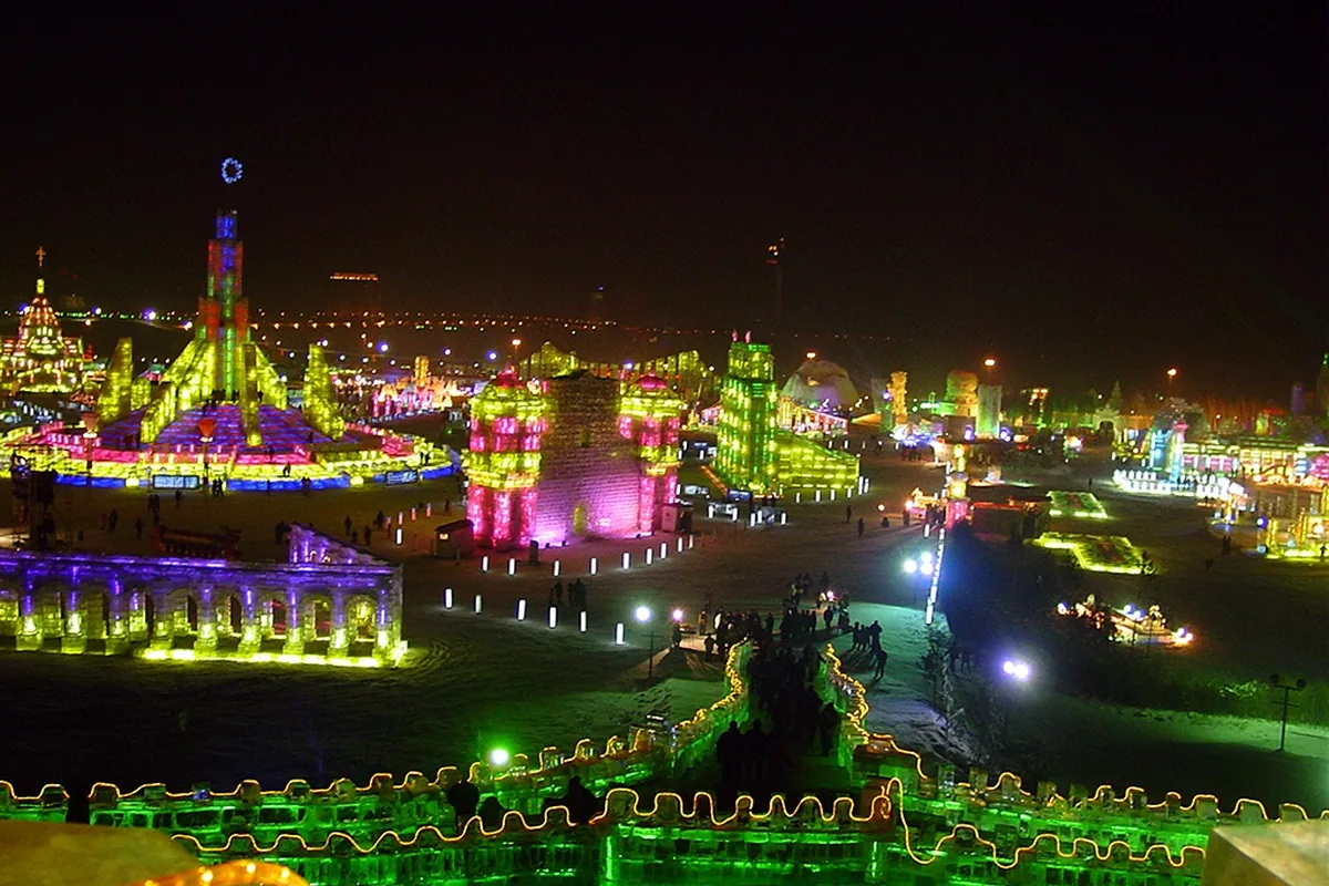 Wide night view of colourful illuminated ice buildings in Harbin