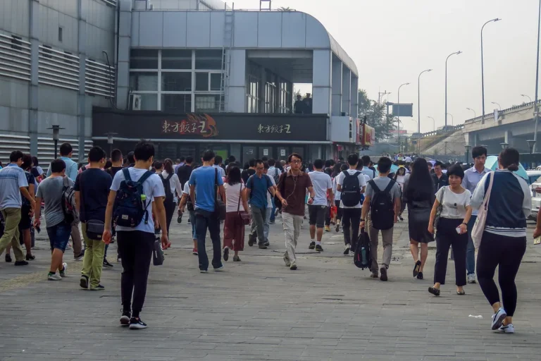 Commuters walking through a busy Beijing metro station