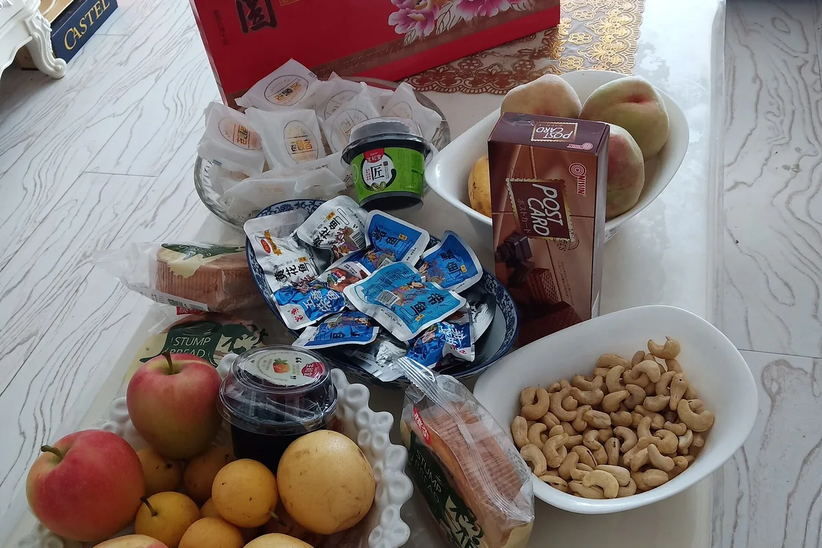 Home Mid-Autumn snack table with mooncakes, fruit and packaged foods