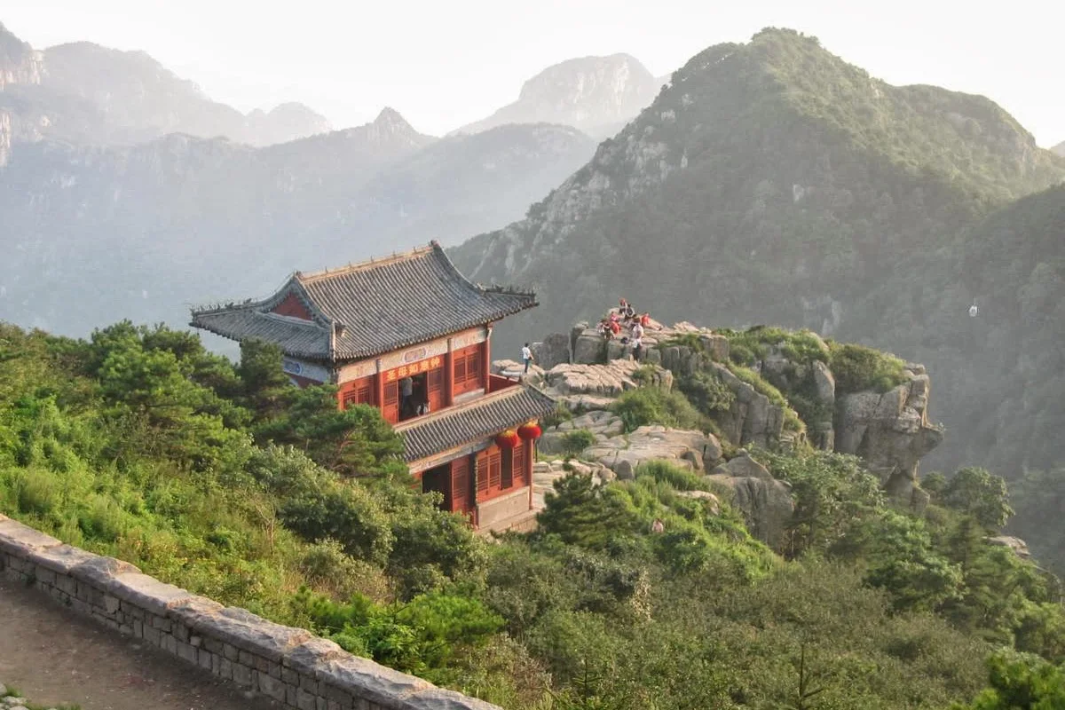 Traditional red building on a rocky ridge at Mount Tai