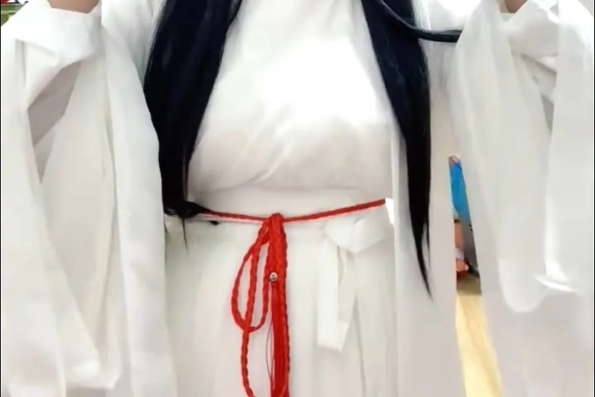 Close view of a white cross-collar Hanfu-inspired garment with red cord