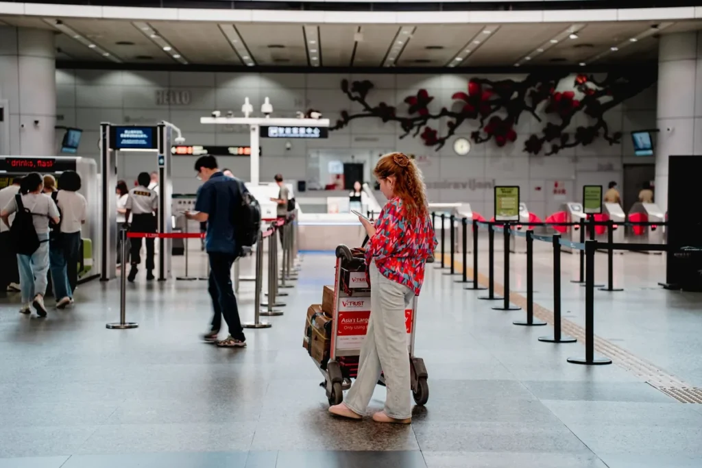 Traveler with luggage cart at Guangzhou airport terminal