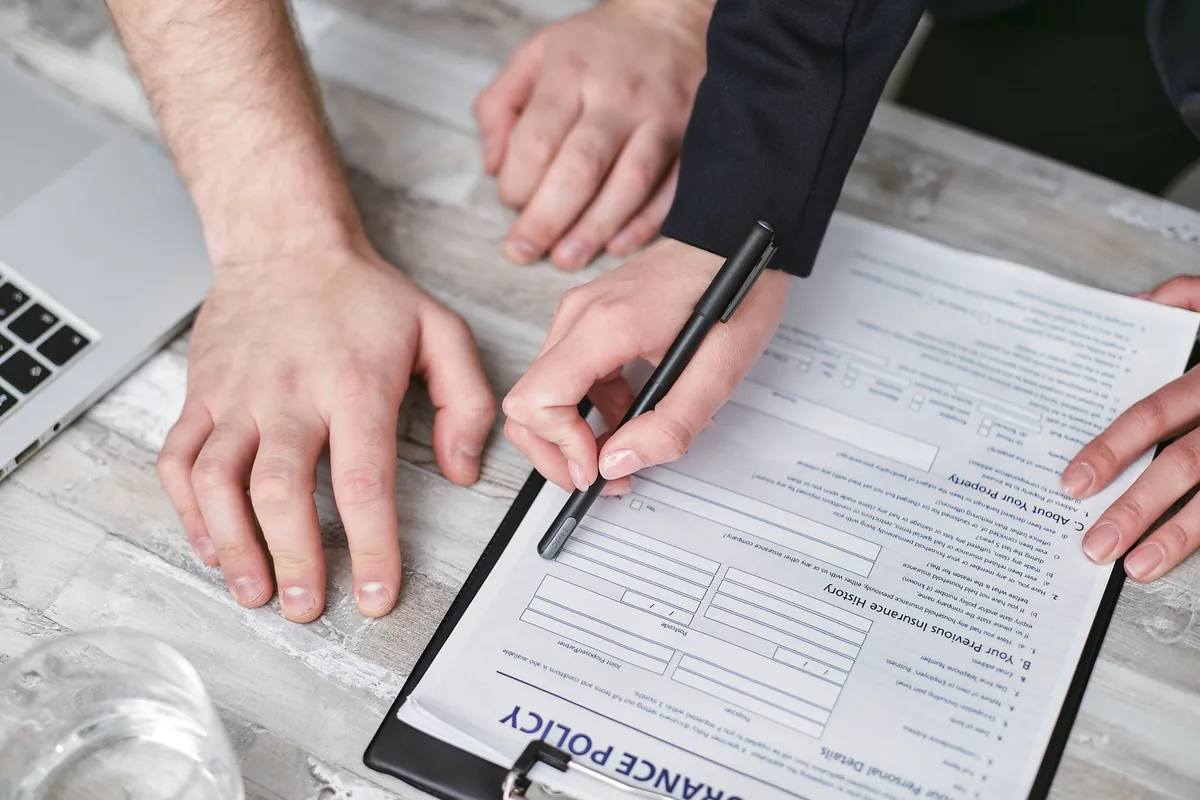 People reviewing and signing an insurance policy document