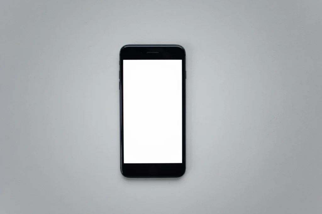 Blank-screen smartphone on a grey surface